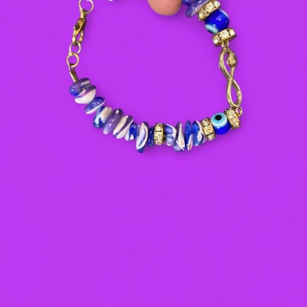 Gold toned Blue and white beaded bracelet with gold accents and evil eye